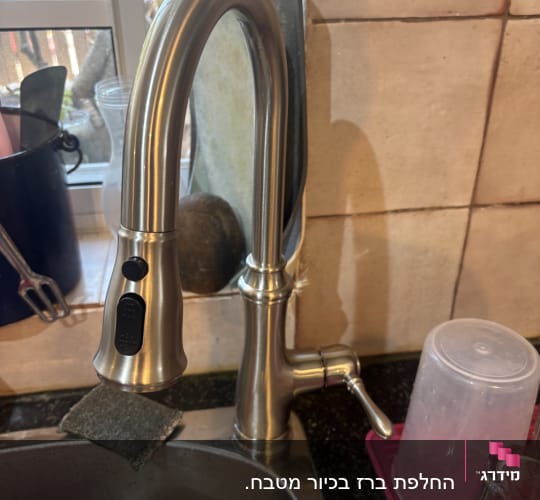ברז מטבח נירוסטה מעל כיור עם כלים